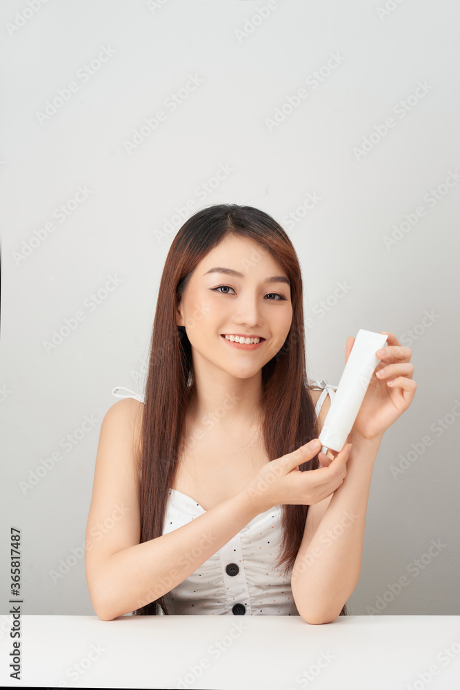 Beautiful Young Asian Woman holding luxury white clean tube smile feeling so happy and cheerful Beautiful Young Asian Woman holding luxury white clean tube smile feeling so happy and cheerful