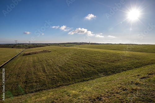 Green field and  bright sun and underground storage center of radioactive waste under the field.  France, Cherbourg. .