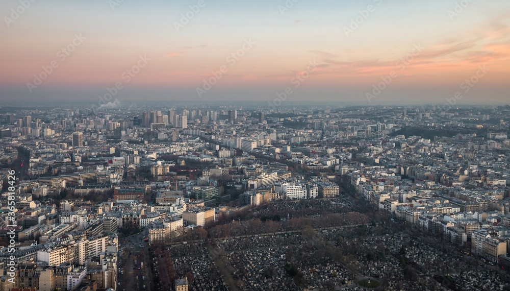 Aerial view of Paris cityscape -  roads, streets and buildings and the Montparnasse Cemetery, the resting place to many famous philosophers, artists, actors, and writers. France, evening.