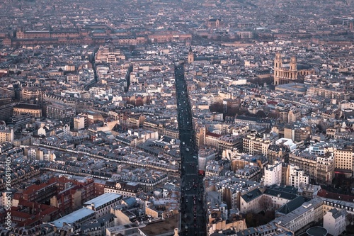 Aerial view of Paris cityscape - wide road and many streets and buildings.  Towers of the roman catholic Church of Saint-Sulpice is on the right. .