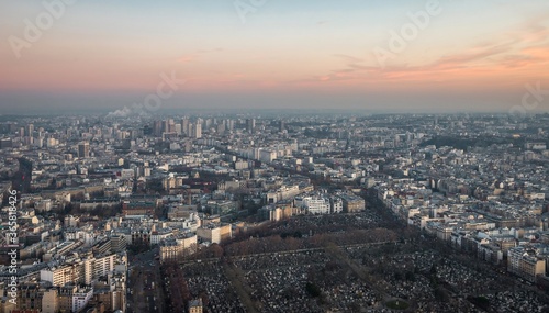 Aerial view of Paris cityscape - roads, streets and buildings and the Montparnasse Cemetery, the resting place to many famous philosophers, artists, actors, and writers. France, evening.