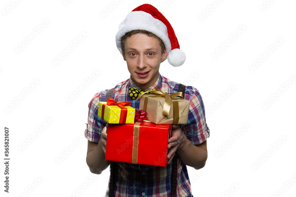 Handsome teenage boy is giving presents for xmas. Wearing red christmas hat. Isolated on white. Handsome teenage boy is giving presents for xmas. Wearing red christmas hat. Isolated on white.