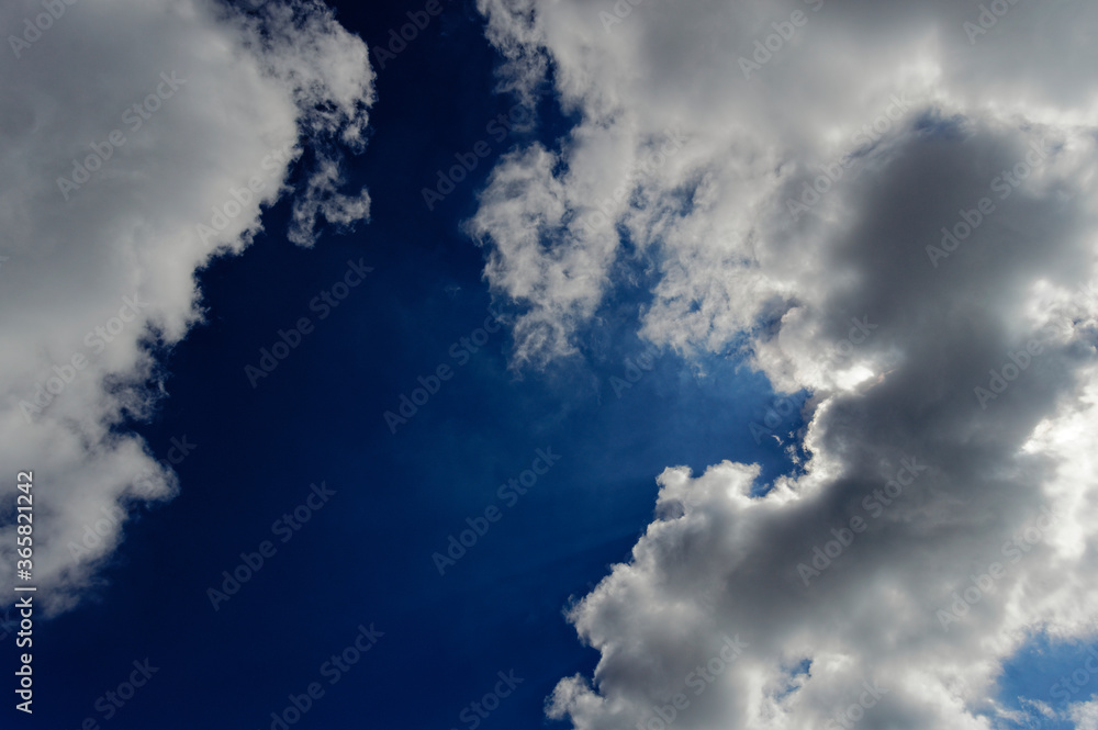 Obraz premium Blue sky with clouds and sun behind