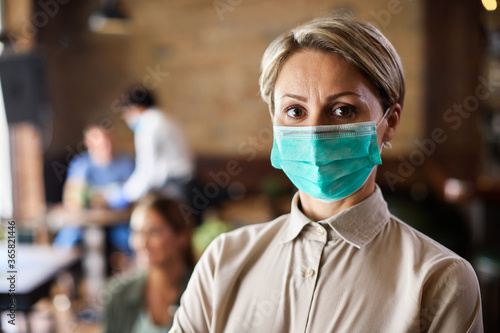 Portrait of waitress wearing protective face mask while working in a cafe.