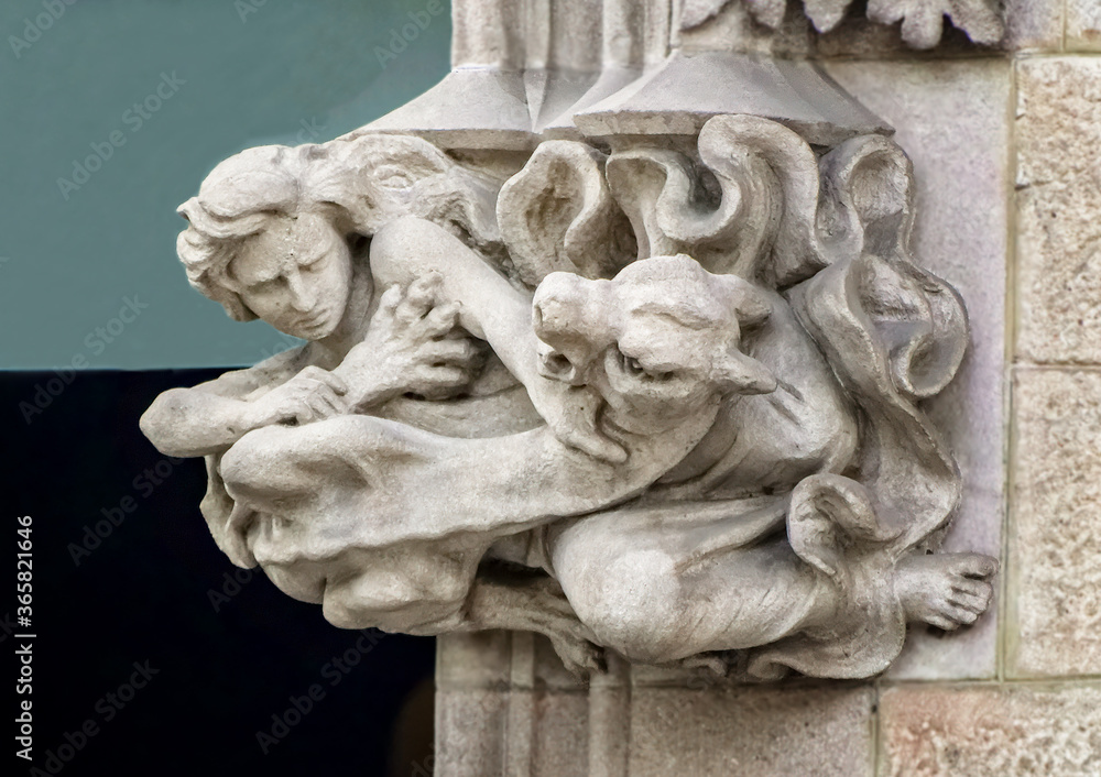 A man is fighting with a beast bas relief sculpture in Barcelona, Spain.