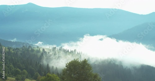 The slow motion footafe of the beautiful mountains anbd forest covered with thick fog during the sunny day. photo