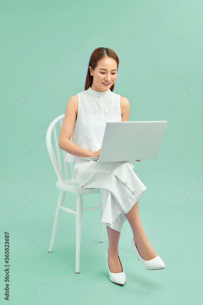 Beautiful student sitting in a chair with a laptop Beautiful student sitting in a chair with a laptop