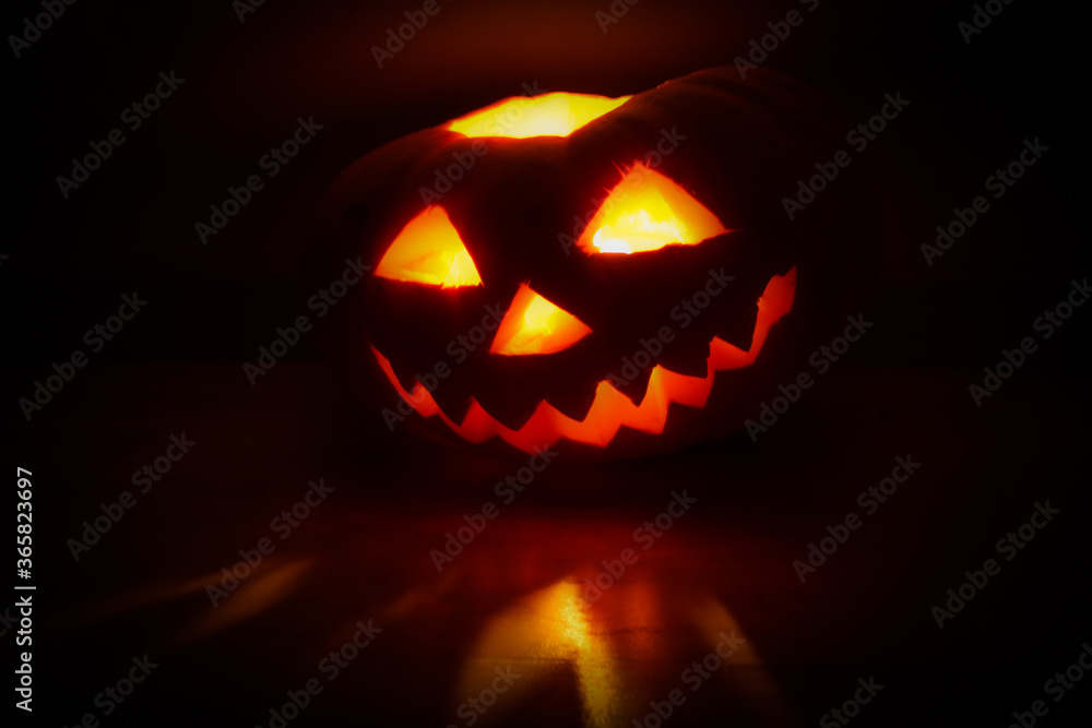 Halloween pumpkin lantern jack glowing in the dark. Reflection of light on surface. Halloween pumpkin lantern jack glowing in the dark. Reflection of light on surface.