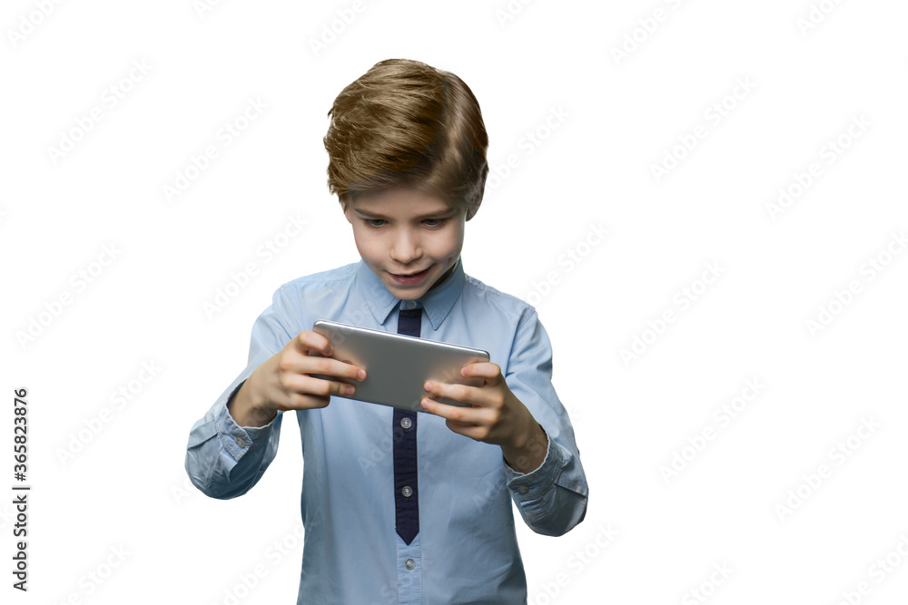 Boy in blue t-shirt enthusiastically plays on the phone. Gadget dependence concept. Boy in blue t-shirt enthusiastically plays on the phone. Gadget dependence concept.