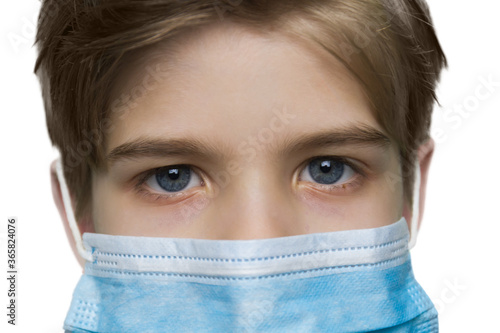 Close up portrait of a young boy in medical mask on white background. Protection during the quarantine.