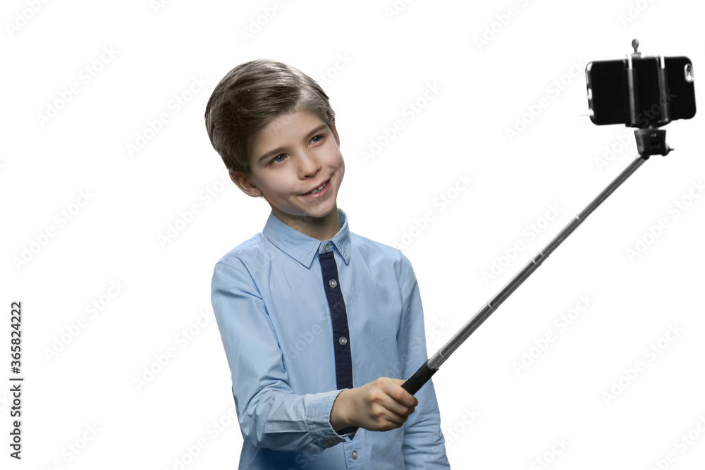 Happy little boy taking selfie using a stick. Isolated on white background. Happy little boy taking selfie using a stick. Isolated on white background.