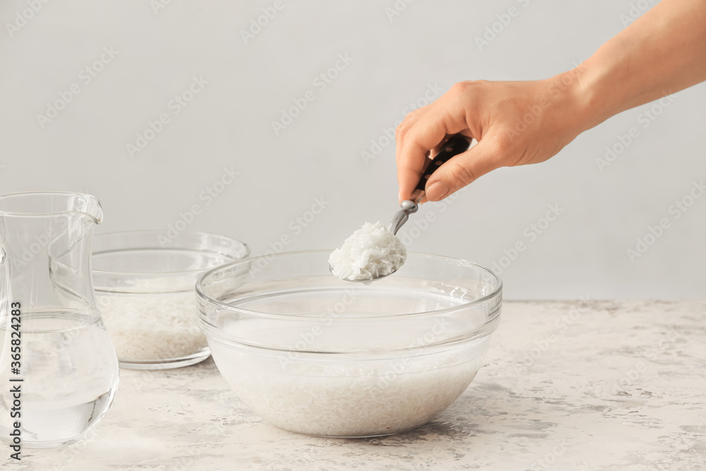 Woman preparing rice water on table Woman preparing rice water on table