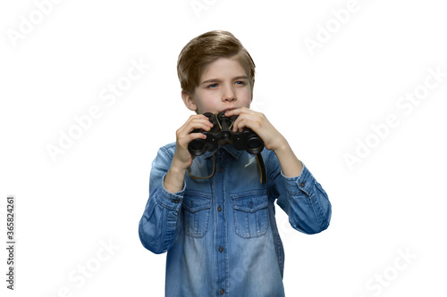 Fotografie Little boy peering into distance and holding binoculars in his hands
