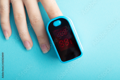 Foto The pulse oximeter shows saturation on a finger on a blue background