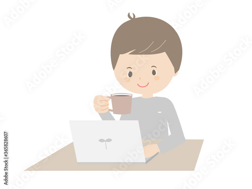 Young man drinking coffee while looking at a laptop.