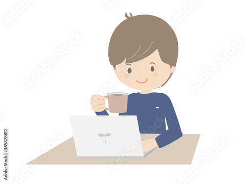 Young man drinking coffee while looking at a laptop.