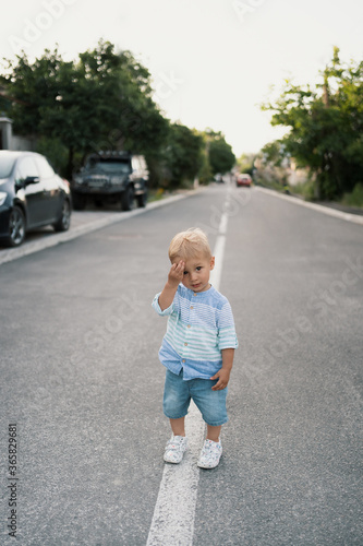 Portrait of the cute little boy walking on the road in his neighbourhood © arthurhidden