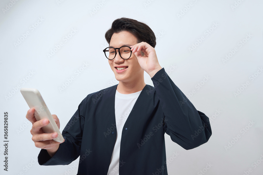 Young handsome Asian man being surprised after reading message from smarrtphone studio short isolated Young handsome Asian man being surprised after reading message from smarrtphone studio short isolated