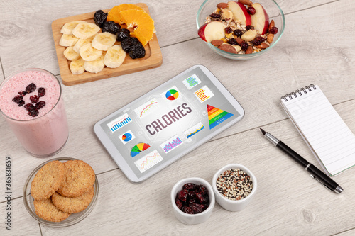 Organic food and tablet pc showing CALORIES inscription, healthy nutrition composition