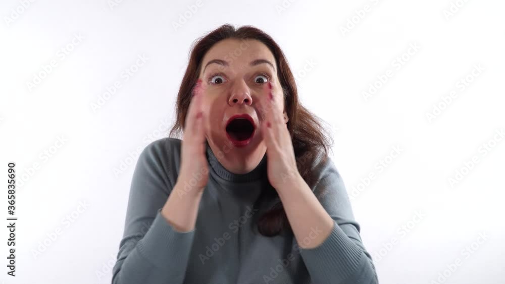 Beautiful woman 30-35 years old brunette shows an emotion of horror or strong surprise. She covers her mouth with her hands. Beautiful woman 30-35 years old brunette shows an emotion of horror or strong surprise. She covers her mouth with her hands.