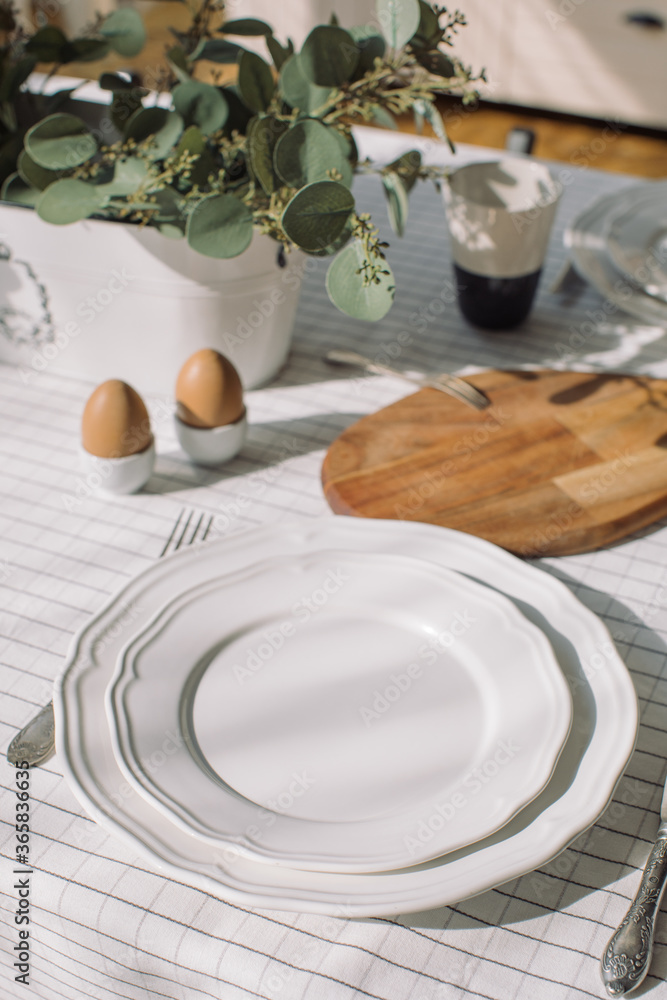 Empty plates on dining table. Elegant crockery prepared for breakfast. Empty plates on dining table. Elegant crockery prepared for breakfast.