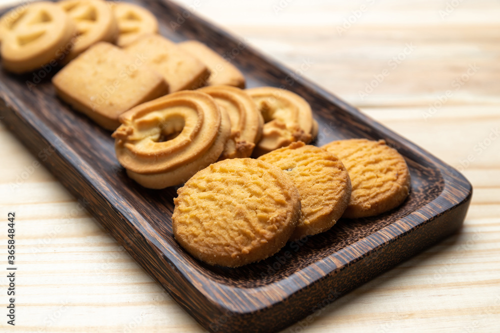 Cookies in a wooden plate on wooden table Cookies in a wooden plate on wooden table