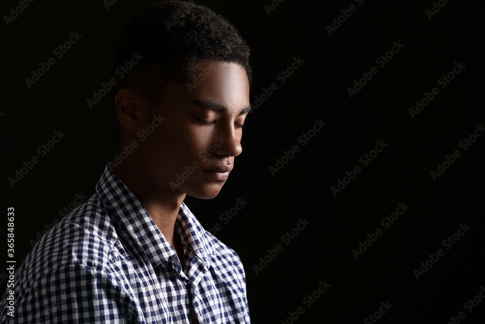 Sad African-American teenage boy on dark background. Stop racism Sad African-American teenage boy on dark background. Stop racism