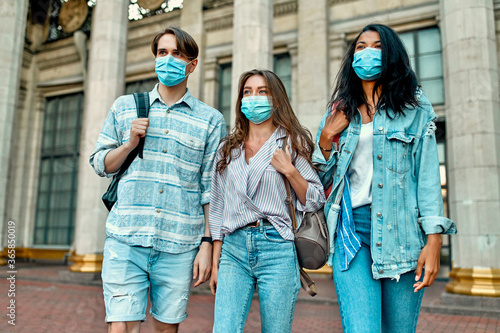 A group of students wearing protective medical masks near the campus.