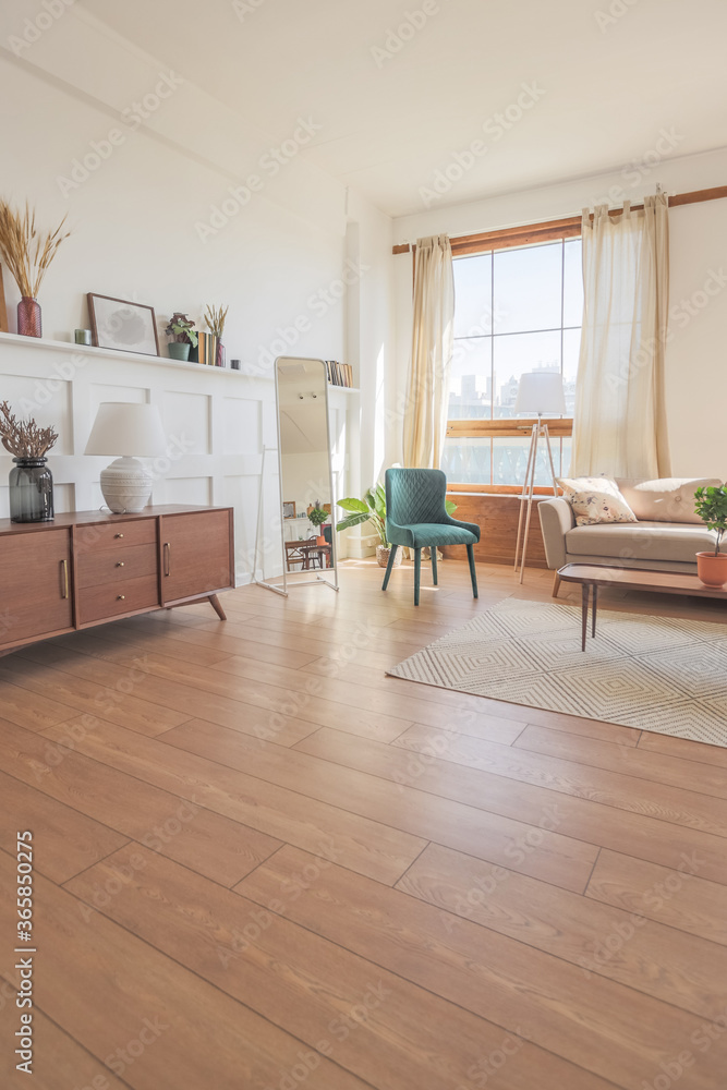 Vintage studio apartment interior in light colors in old style. huge room with large windows with a living room area and a bedroom area. direct sunlight inside.