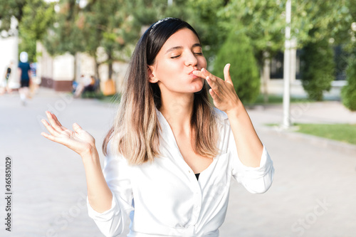 Φωτογραφία portrait of beautiful woman in white shirt and hair bezel with mouth full of foo