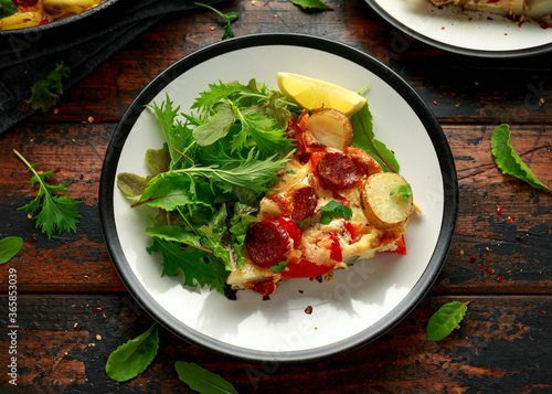 Chorizo Frittata with salad on black and white plate. healthy morning breakfast food