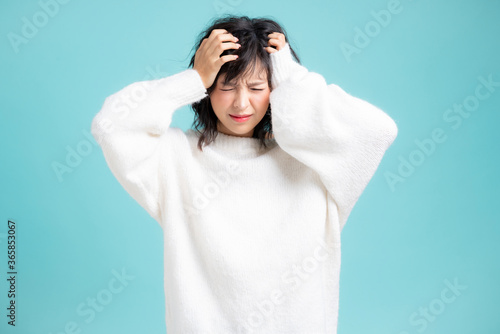 Nervous young Asian girl image isolated on blue studio background.