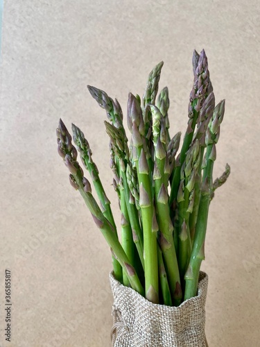Fresh green asparagus on a light background. In an eco-friendly bag