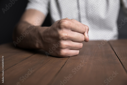 angry man fists on table