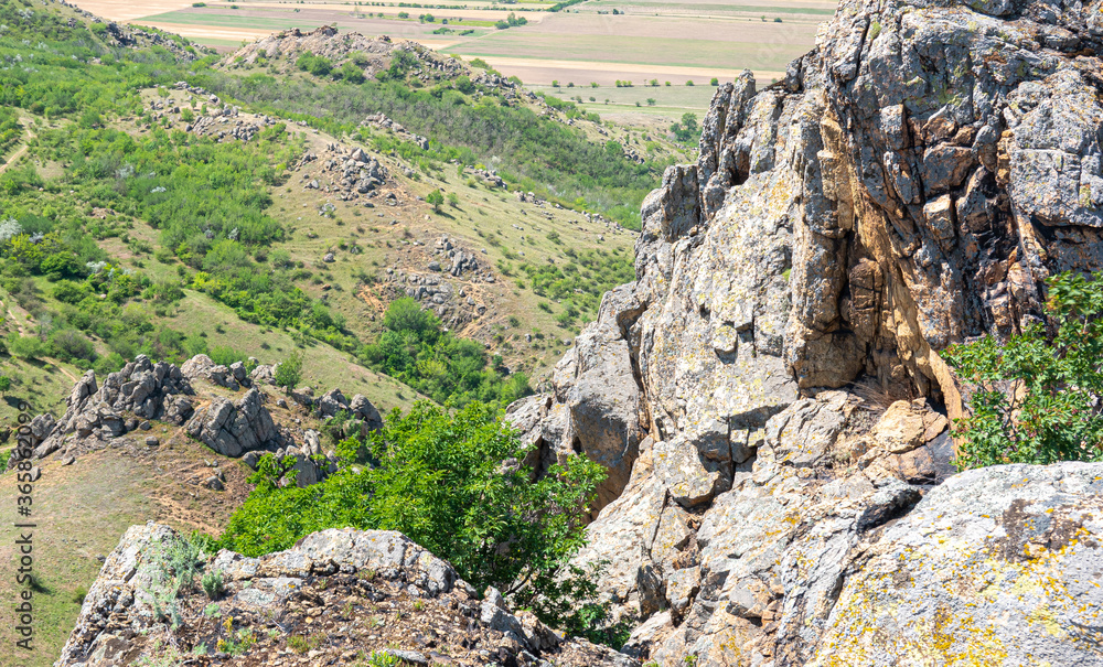 Hiking on the oldest mountains in Romania - Macin Mountains from Dobrogea region of the country - blue sky white clouds and rocks in low vegetation Hiking on the oldest mountains in Romania - Macin Mountains from Dobrogea region of the country - blue sky white clouds and rocks in low vegetation