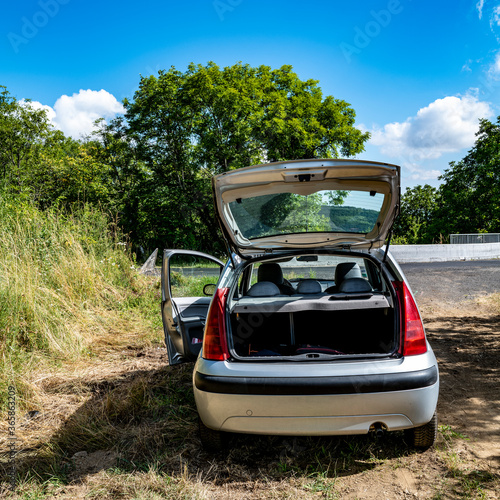 voiture stationnée dans un chemin portiere gauche et coffre ouverts photo