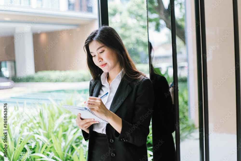 Beautiful young asian woman taking notes