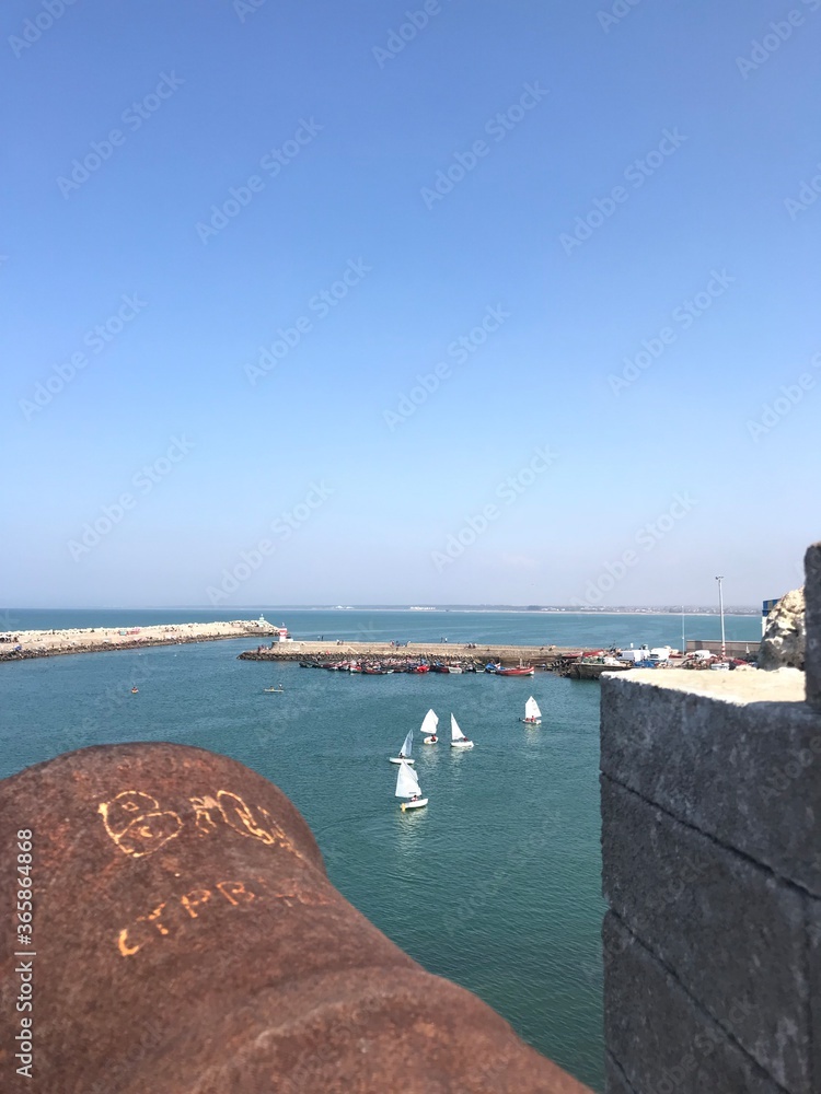 El Jadida / Morocco - 09 08 2019: View of the defending walls of Mazagan - a Portuguese fortified port city, a UNESCO heritage site. Long walls around the city, bordering the sea. Artillery guns area.