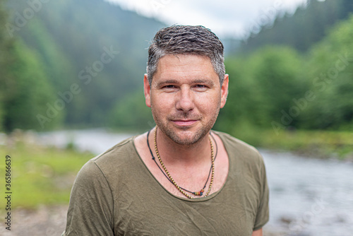 Portrait of an attractive young man against a background of wild nature.