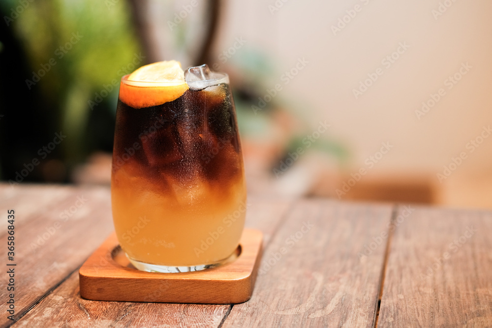 A glass of ice black coffee with paper straw in coffee cafe A glass of ice black coffee with paper straw in coffee cafe