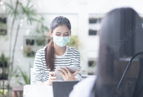 Group of asian business women wearing medical face mask are working together outside by social distancing.