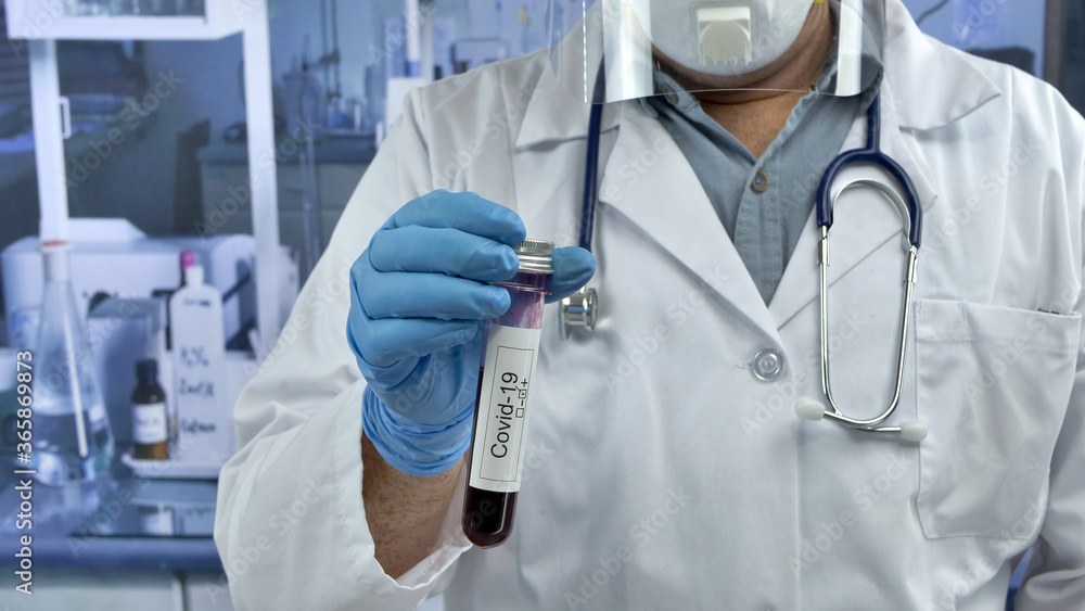 Doctor holding a tube of covid-19 test. Doctor holding a tube of covid-19 test.