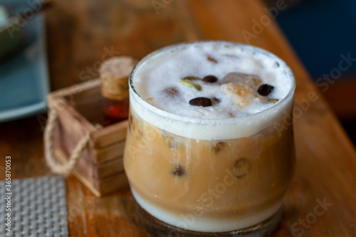 Glass of ice coffee. Cold Coffee On a wooden Table. Selective focus, Summer drink iced coffee in glass and coffee beans on a table.