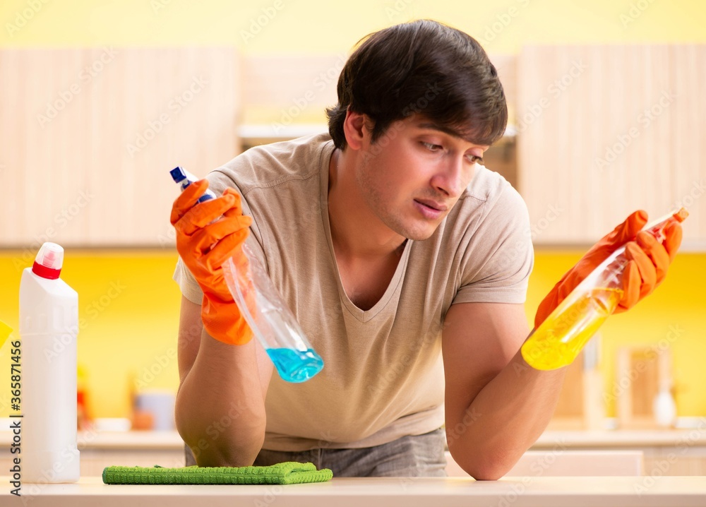 Single man cleaning kitchen at home Single man cleaning kitchen at home