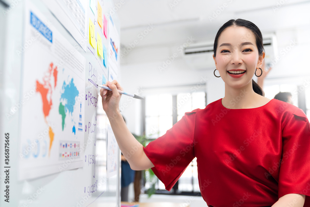 asian businesswoman standing present profit growth and strategy plan for goal target achieve to board and team colleague business discussion meeting with modern white design interior office asian businesswoman standing present profit growth and strategy plan for goal target achieve to board and team colleague business discussion meeting with modern white design interior office