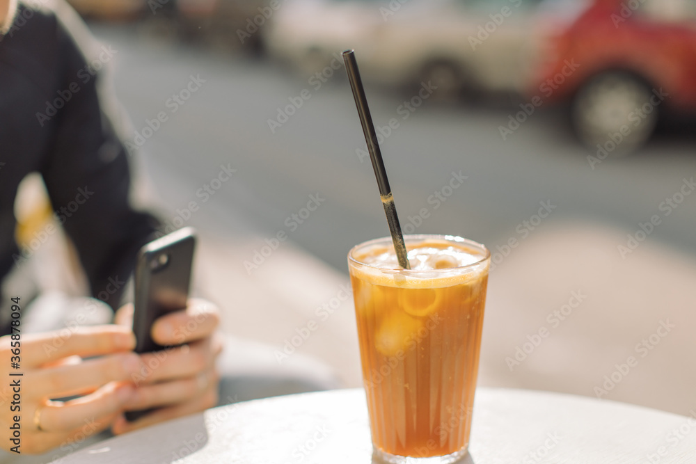 Glass of refreshment drink with espresso on summer terrace in the city. Copy space, summer cocktails concept.