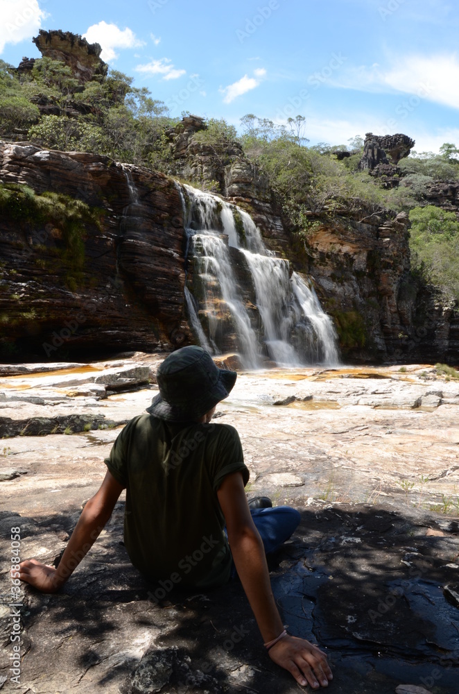 Man looking at waterfall in Rio Preto State Park in Minas Gerais at Cachoeira da Semper-Viva (translate to Always-Alive Waterfall, with is the popular name of Actinocephalus polyanthus) Man looking at waterfall in Rio Preto State Park in Minas Gerais at Cachoeira da Semper-Viva (translate to Always-Alive Waterfall, with is the popular name of Actinocephalus polyanthus)