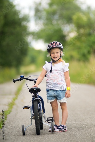 Fototapeta Naklejka Na Ścianę i Meble -  The first bike ride a little girl learns to ride a bicycle.