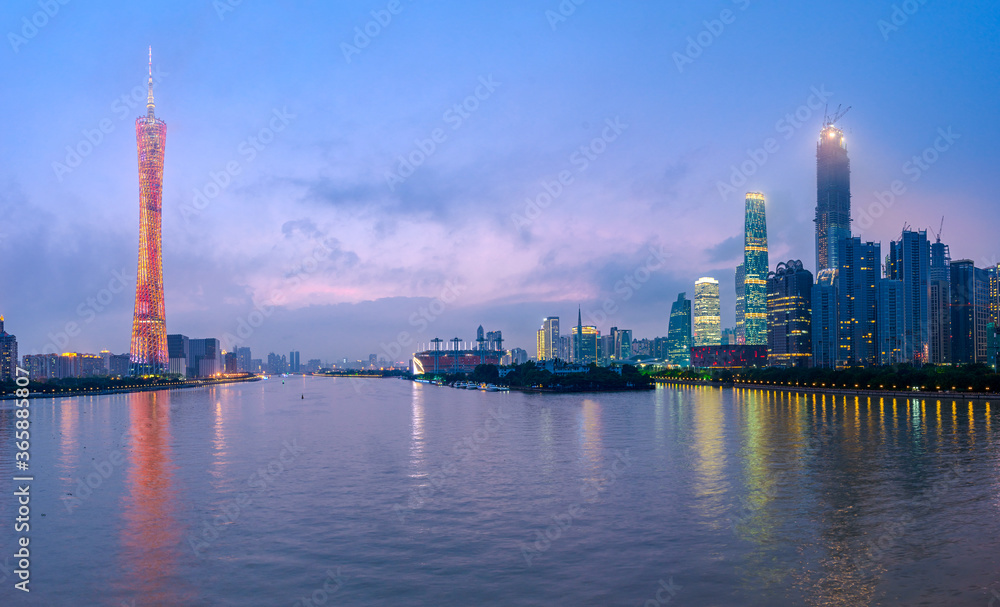 Guangzhou, China skyline on the river at dusk.