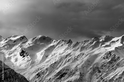 High snowy mountains and sunlight storm sky in evening